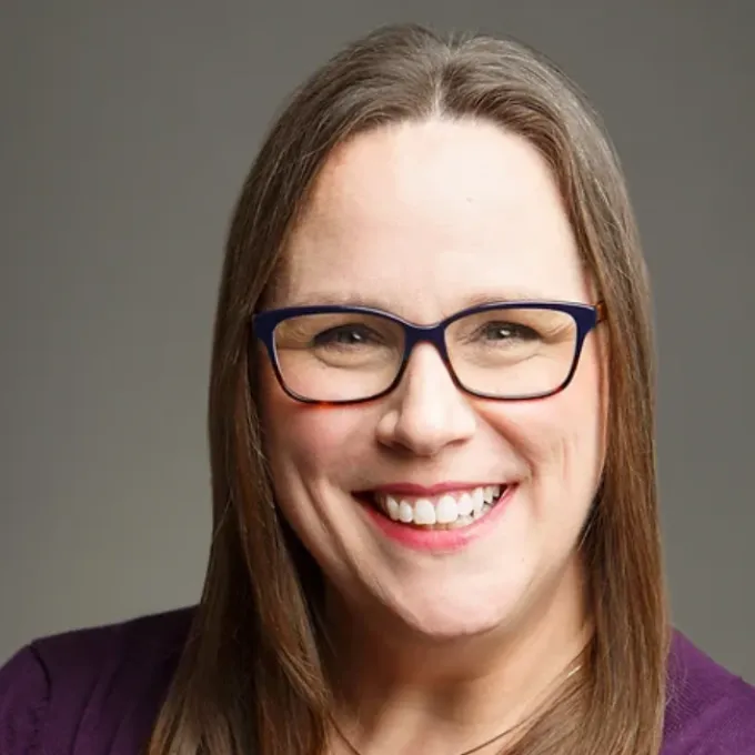 Image of a white woman with brown hair and glasses