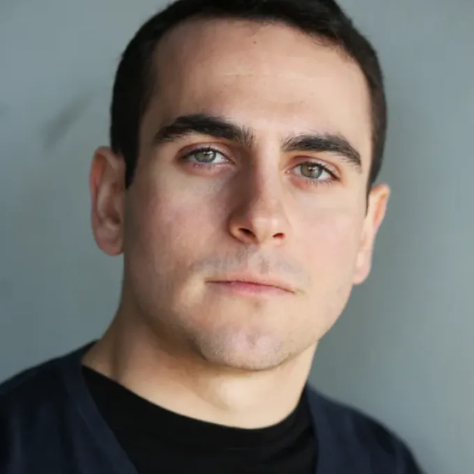 A white man with short black hair in a black t-shirt