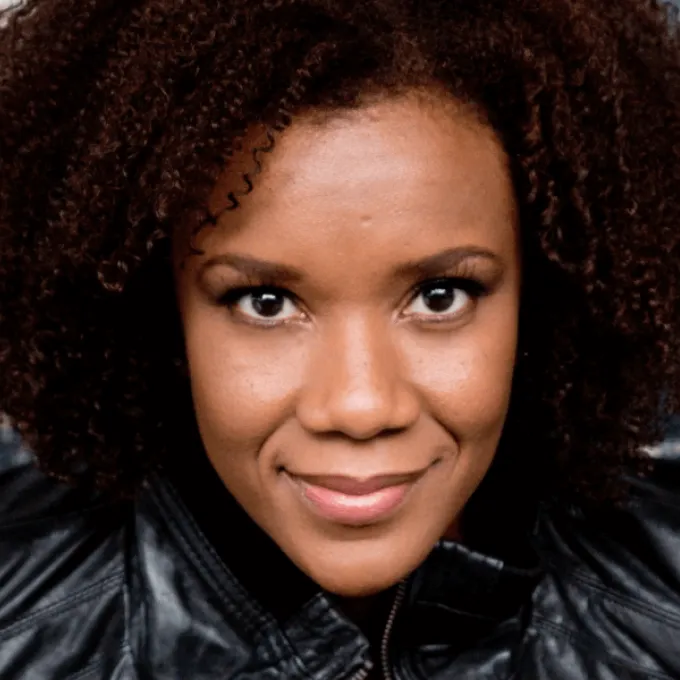 Close up of a Black woman with curly hair in a black shirt